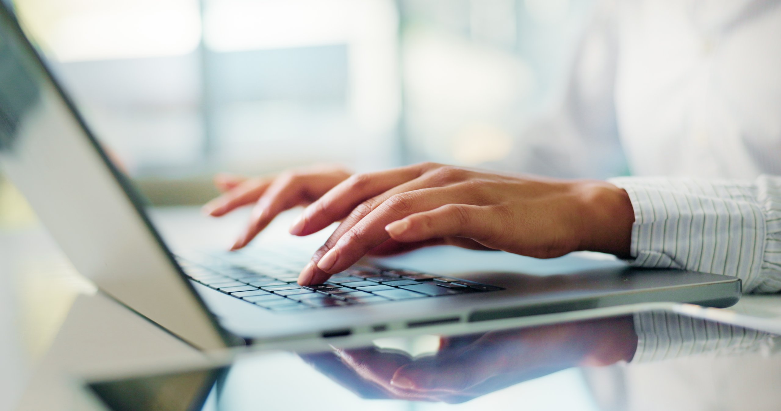 Professional accountant working on laptop reviewing financial documents